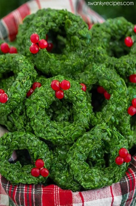 Christmas Corn Flake Wreath Cookies with green garland and cinnamon candies as bows.