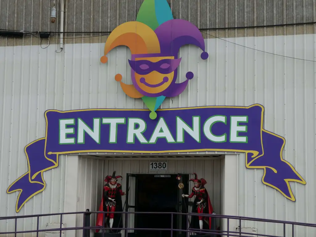 20 Must-Try Foods and Activities in New Orleans 11 The entrance to Mardi Gras World in New Orleans is vibrant and welcoming, featuring a large, colorful sign that reads "Entrance" in bold, festive letters.