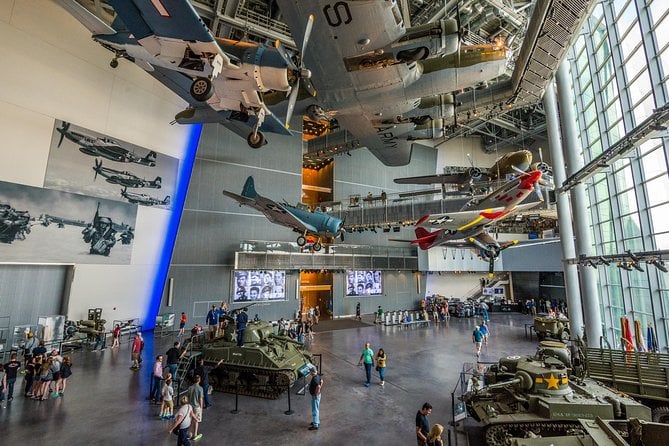 20 Must-Try Foods and Activities in New Orleans 28 Interior view of the National WWII Museum, showcasing a spacious exhibit hall with aircraft suspended from the ceiling.